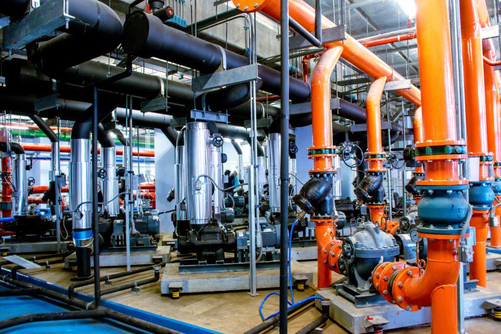 Orange and blue pumps and headers in a central plant
